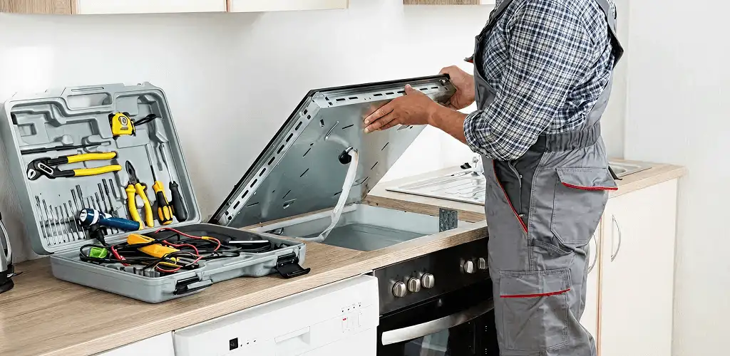 Handyman repairing a cooktop and checking wiring connections in Clearwater, FL