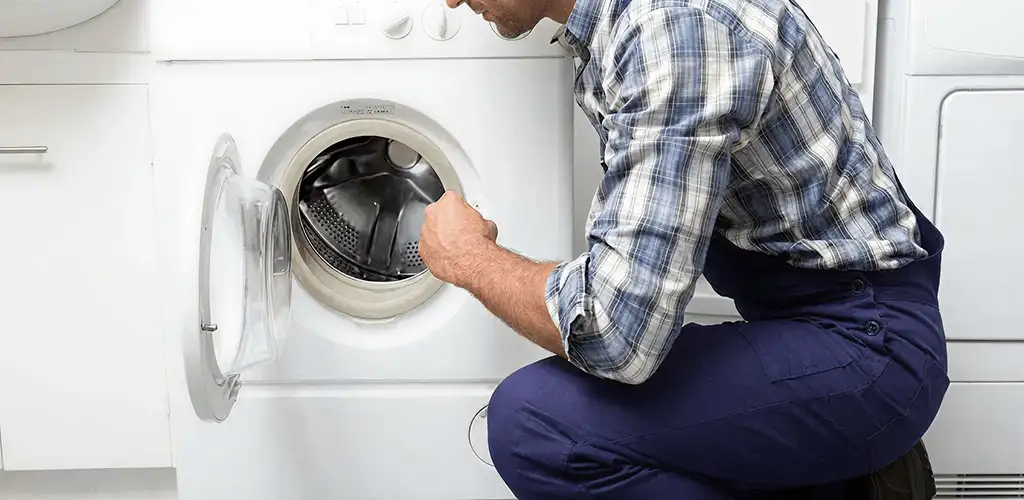 Handyman inspecting a dryer drum and internal parts for repair in Clearwater, FL