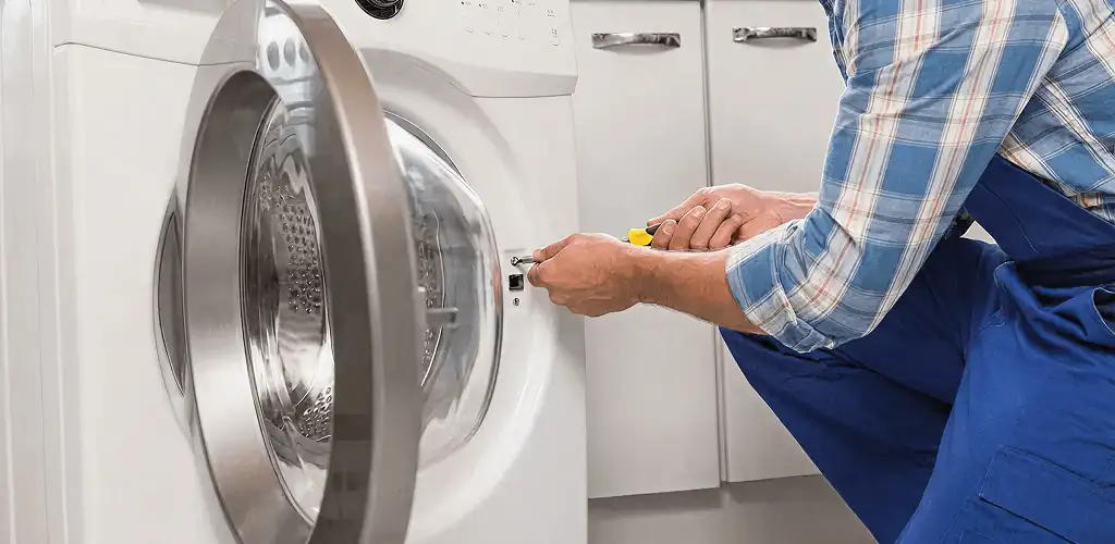 Handyman repairing a clothes dryer and checking electrical connections in Clearwater, FL