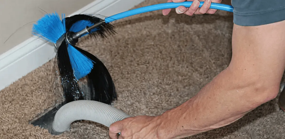 Dryer vent cleaning technician brushing lint from a vent line in Clearwater, FL