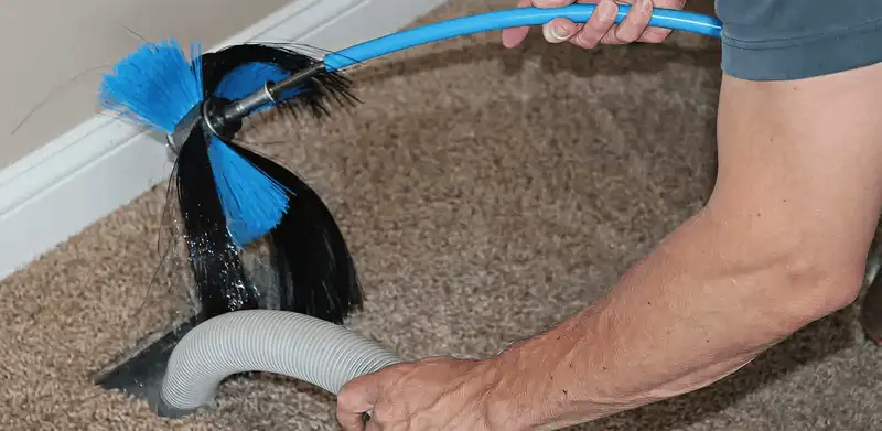 Dryer vent cleaning technician brushing lint from a vent line in Clearwater, FL