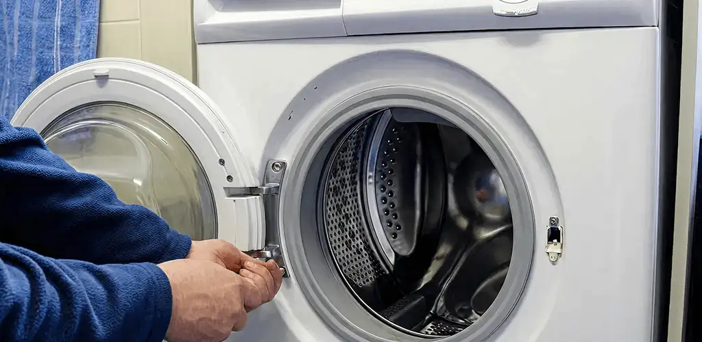 Washing machine repair handyman checking a front-load washer door and latch in Clearwater, FL
