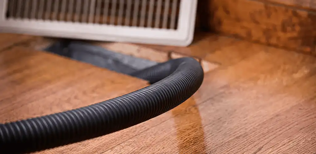 Air duct cleaning hose inserted into a floor vent for ductwork cleaning in Clearwater, FL
