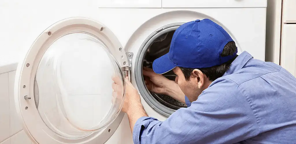 Washing machine repair handyman inspecting a front-load washer drum in Clearwater, FL