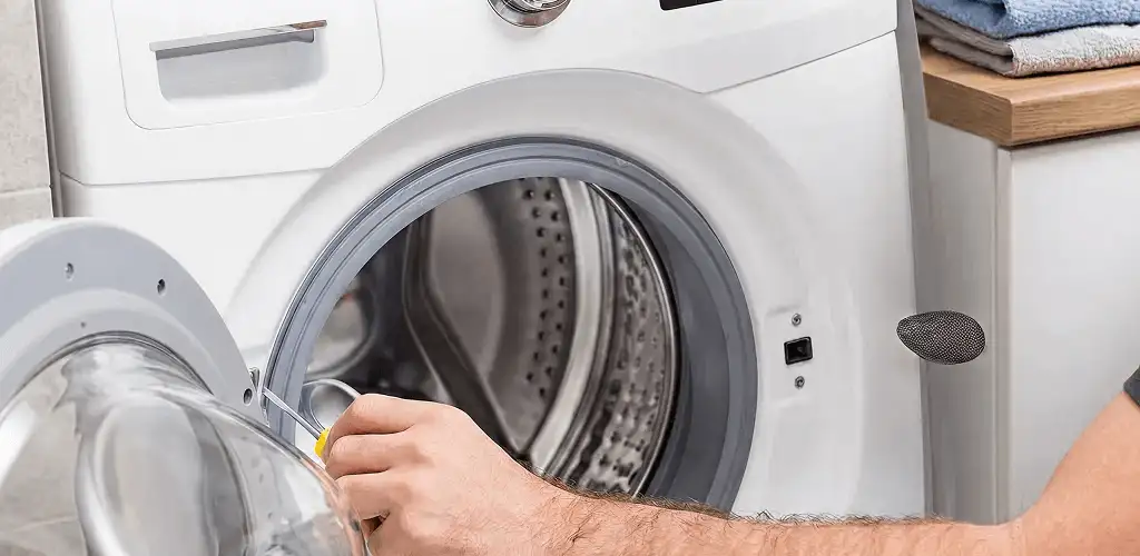 Handyman repairing a front-load washing machine and inspecting the drum in Clearwater, FL