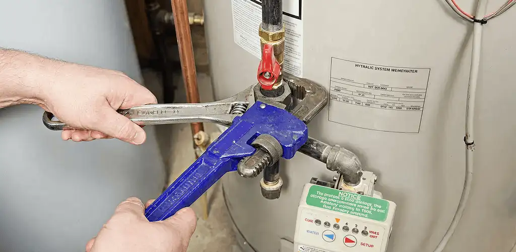 Water heater repair technician tightening the shutoff valve and supply line in Clearwater, FL